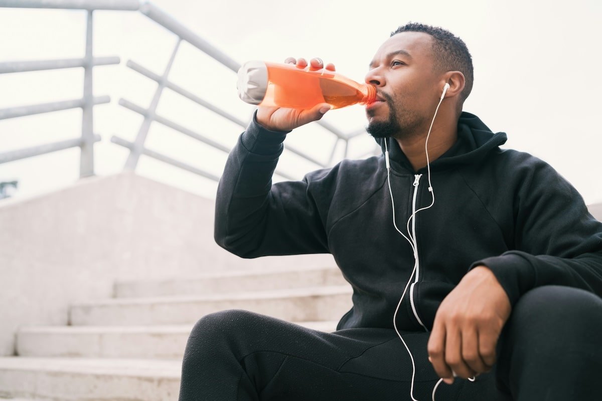 Un sportif s'hydrate lors d'une séance de sport.